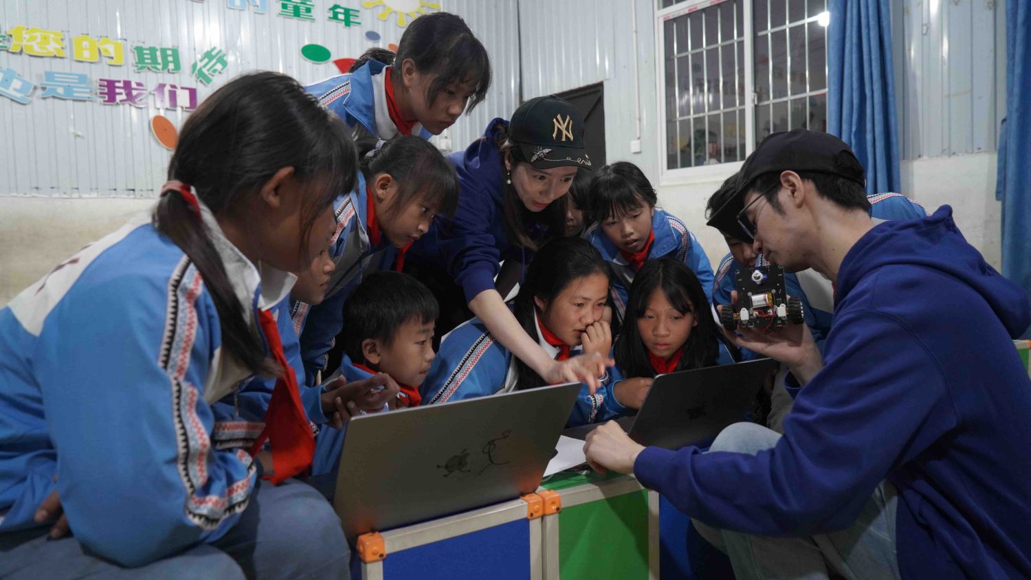 鄉村振興技術官俞淑婷（圖中）和黃建紹（右一）和小朋友們在測試小車代碼