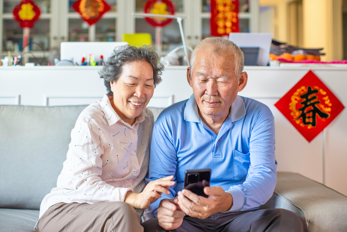 Asian,Senior,Couple,Smiling,And,Looking,At,The,Mobile,Phone