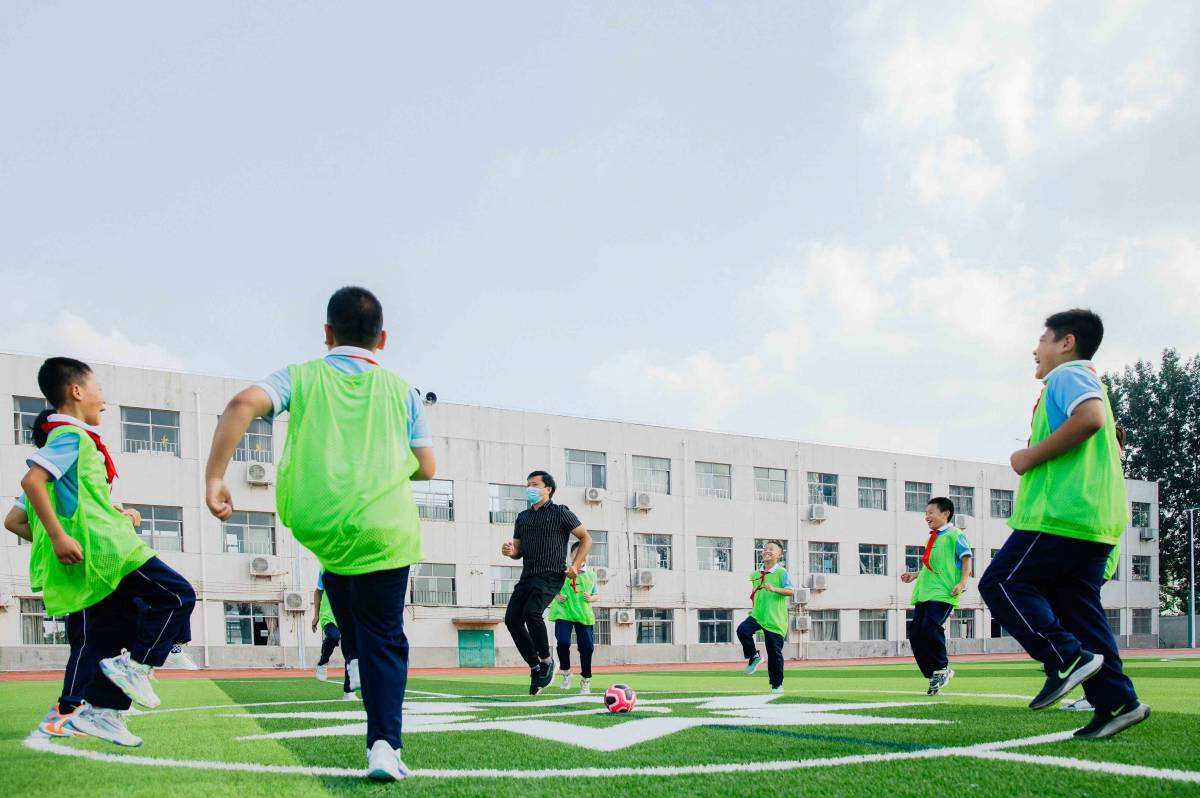 เด็กนักเรียนกำลังอบอุ่นร่างกายบนสนามกีฬาจากยางพาราของไนกี้ เครดิตภาพ:Nike